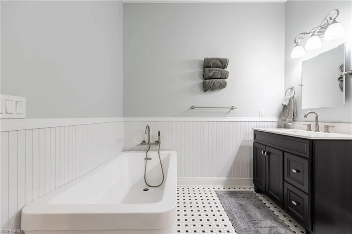 Bathroom with a wainscoted wall, vanity, and a freestanding tub