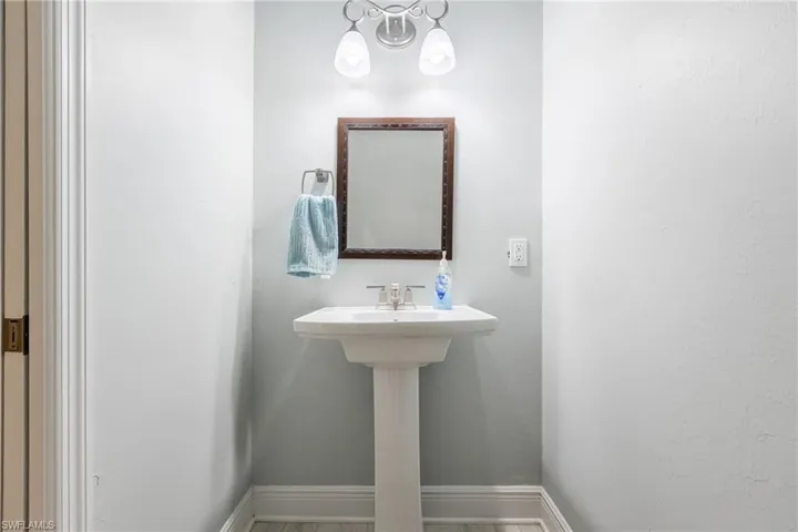 Bathroom featuring wood finished floors and a chandelier