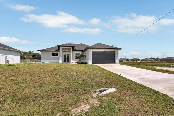 View of front of house featuring a garage and a front yard