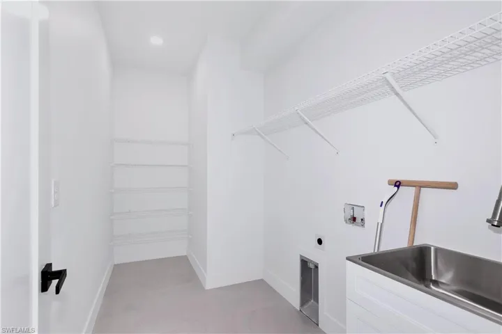 Washroom with sink, light tile patterned floors, and hookup for a washing machine