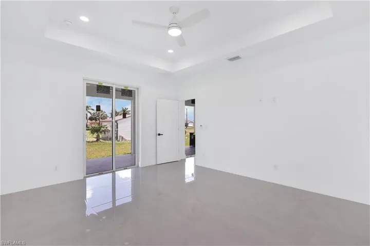 Unfurnished room with ceiling fan, a raised ceiling, and tile patterned floors