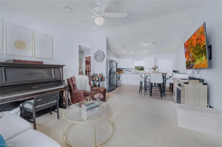 Living area featuring vaulted ceiling, a ceiling fan, recessed lighting, and light wood-type flooring