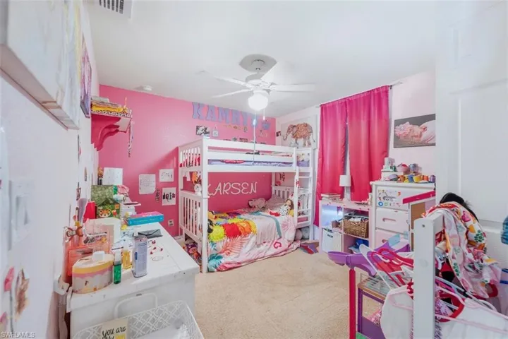 Carpeted bedroom with a ceiling fan