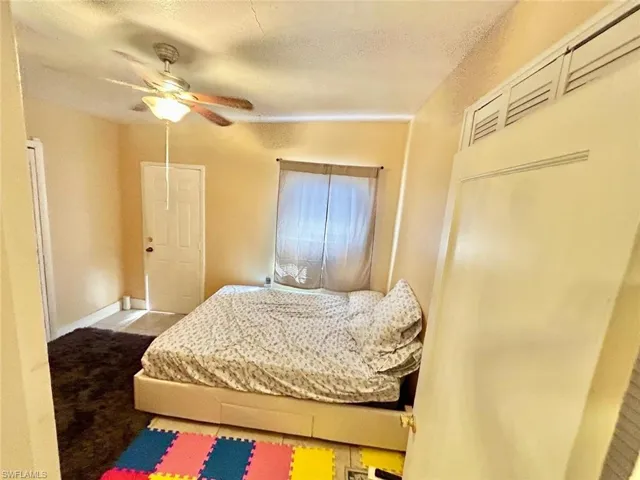 Bedroom with a textured ceiling and a ceiling fan