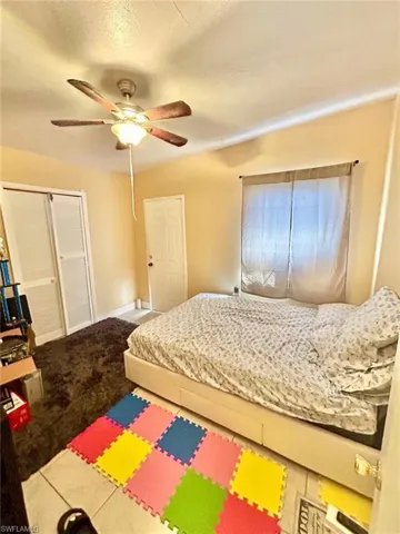 Carpeted bedroom with a closet and a ceiling fan