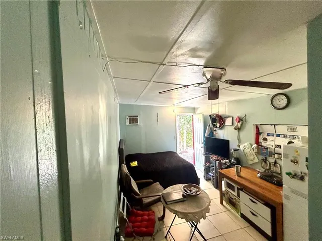 Living room with ceiling fan and light tile patterned floors