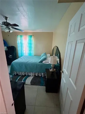 Tiled bedroom featuring a ceiling fan