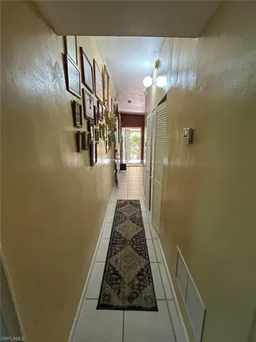 Hall featuring light tile patterned floors