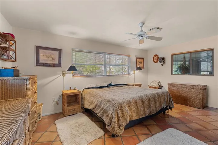 Bedroom with ceiling fan, baseboards, and tile patterned floors