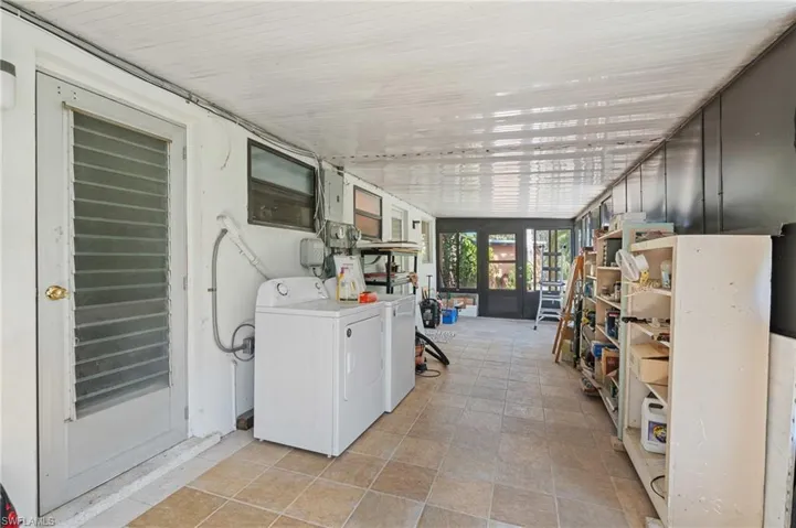 Laundry area with laundry area, washing machine and dryer, and light tile patterned floors