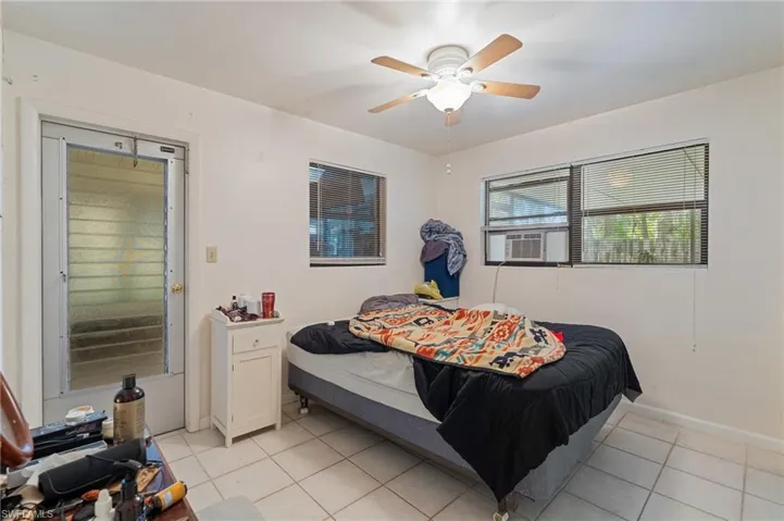 Bedroom with ceiling fan, baseboards, cooling unit, and light tile patterned flooring