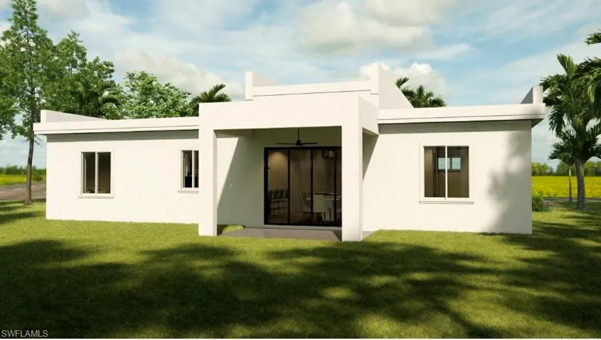 Back of house featuring a ceiling fan, a lawn, and a patio