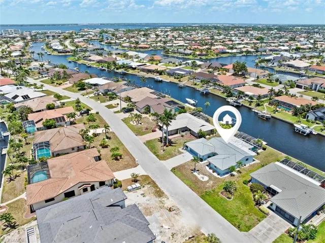 Aerial perspective of suburban area featuring a nearby body of water