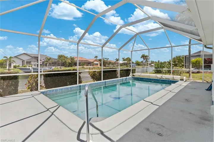 Outdoor pool featuring a water view, a patio, a residential view, and a lanai