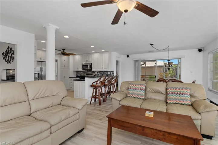 Living room with a ceiling fan, recessed lighting, and light wood-style floors