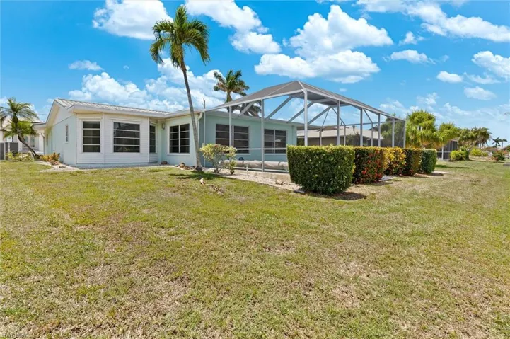 Back of house with a lawn and glass enclosure