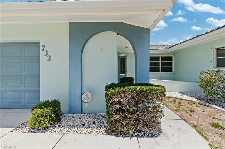 Doorway to property featuring stucco siding and an attached garage