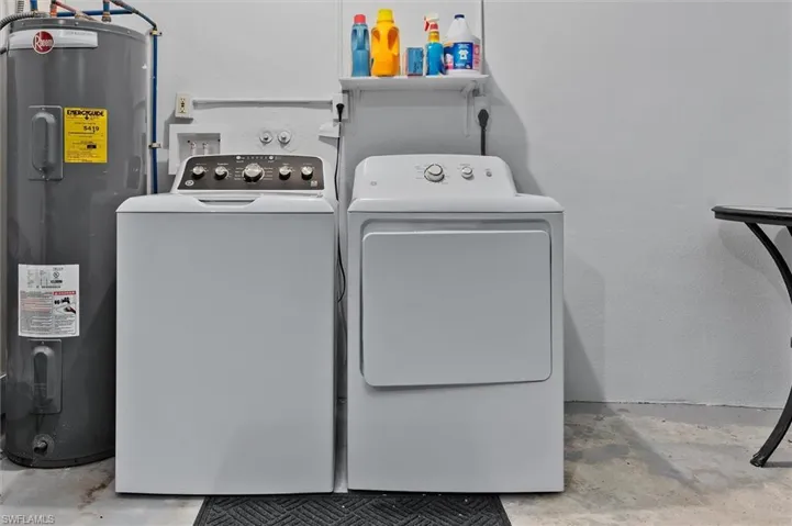 Laundry room featuring washing machine and dryer and electric water heater