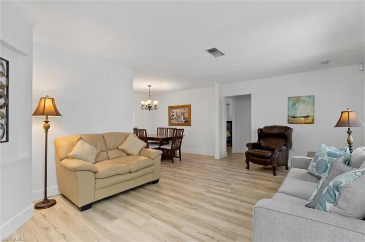 Living area with light wood-style flooring and a chandelier