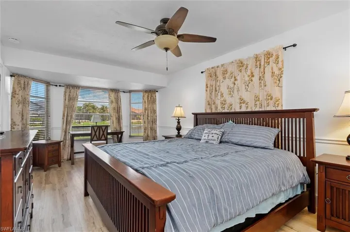 Primary Bedroom with light wood finished floors and a ceiling fan