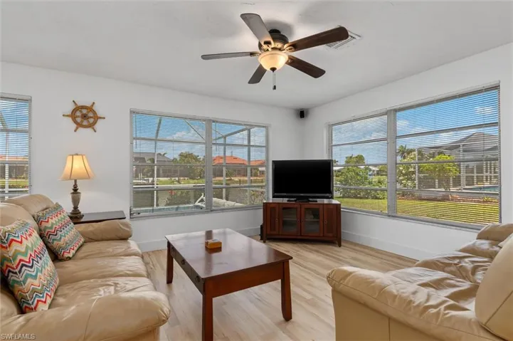Living room with plenty of natural light, light wood-type flooring, and a ceiling fan