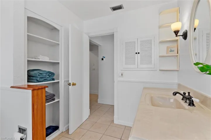 Bathroom featuring tile patterned flooring, a closet, and vanity