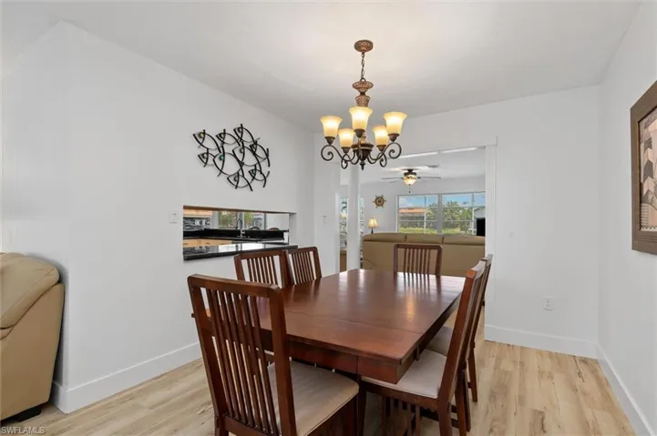 Dining room featuring light wood-style flooring, a chandelier, and ceiling fan