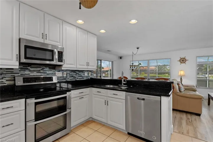 Kitchen with stainless steel appliances, recessed lighting, open floor plan, a peninsula, and tasteful backsplash