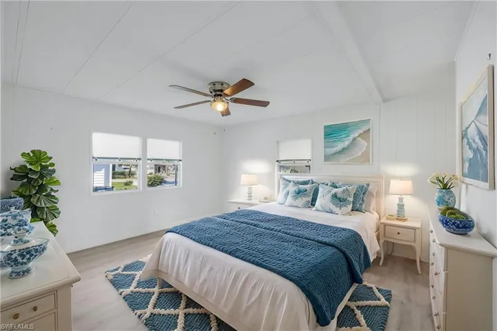 Bedroom with light wood-style flooring, baseboards, beamed ceiling, and ceiling fan