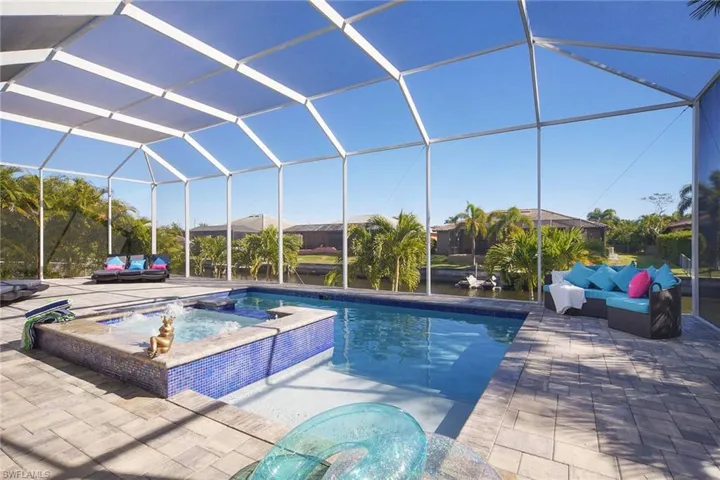 Integrated pool / spa with a sunroom, a lanai, a patio area, and an outdoor living space