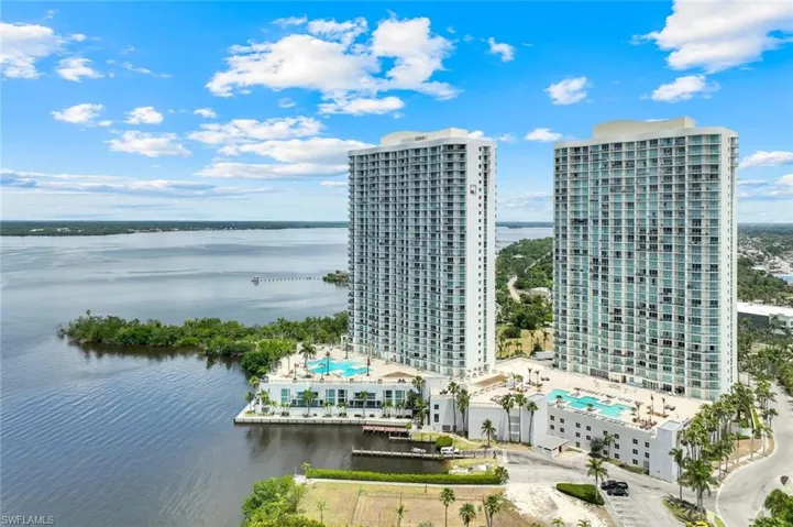 Bird's eye view of a nearby body of water and a pool area
