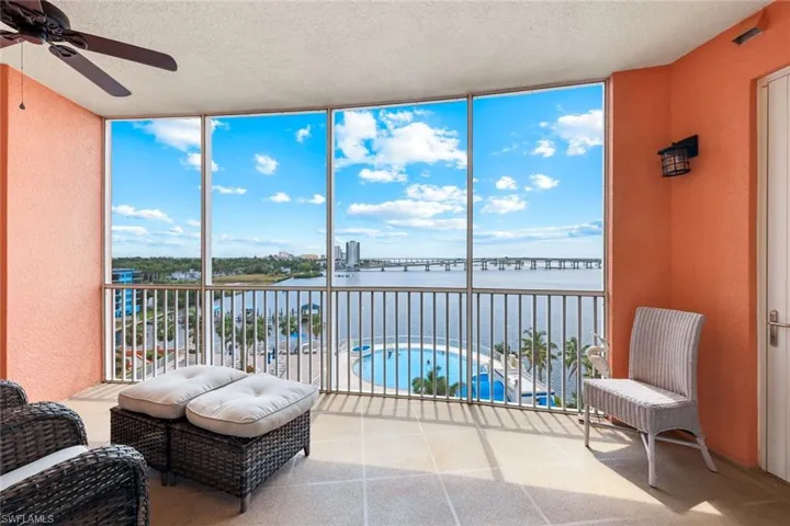 Sunroom featuring a wall of windows, a water view, a textured ceiling, and healthy amount of natural light