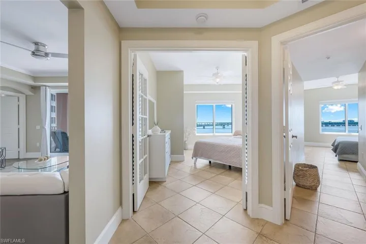 Corridor featuring plenty of natural light, baseboards, and light tile patterned floors