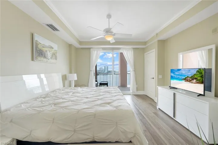 Bedroom with access to exterior, light wood-style floors, ornamental molding, ceiling fan, and baseboards
