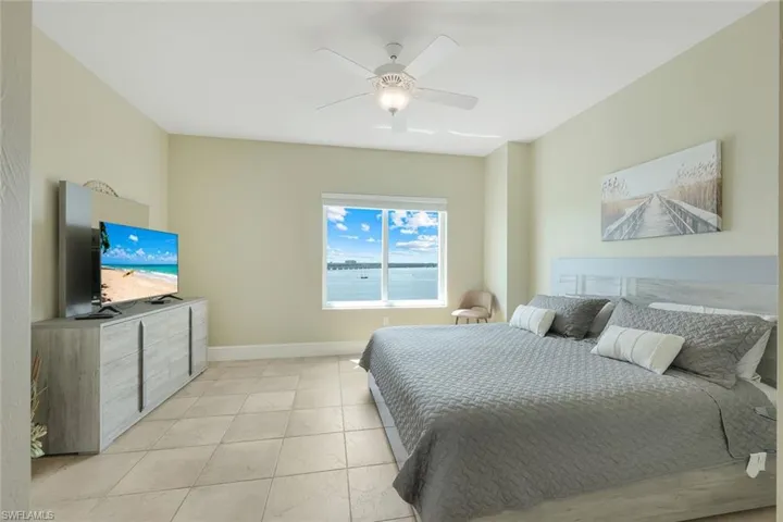 Bedroom with ceiling fan, baseboards, and light tile patterned flooring