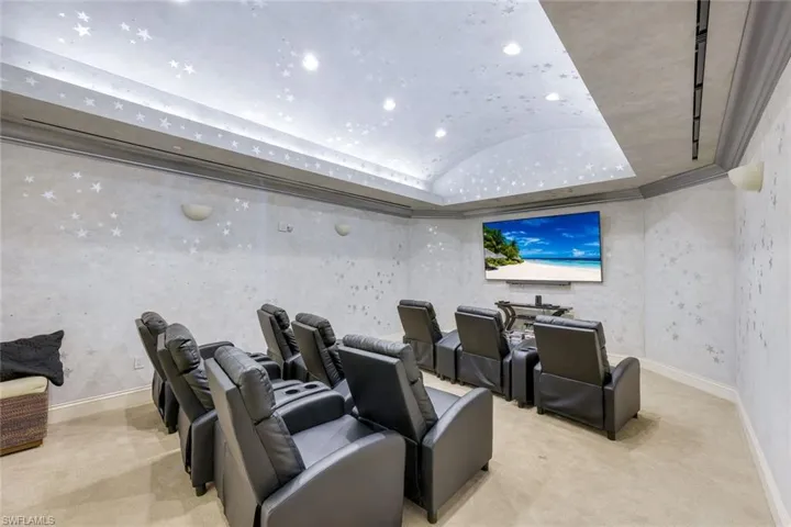 Home theater with vaulted ceiling, recessed lighting, and baseboards