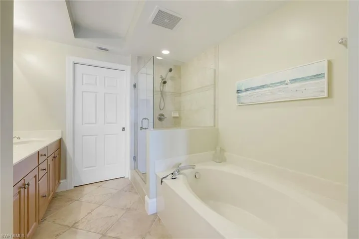 Bathroom with a stall shower, a bath, and vanity