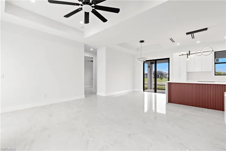 Empty room with a raised ceiling and ceiling fan