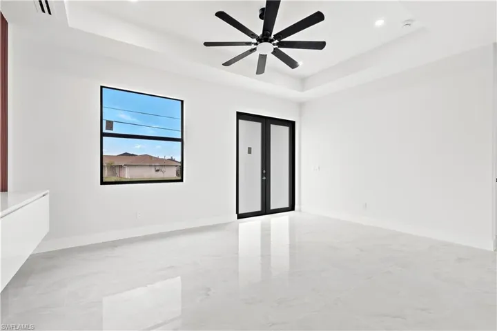 raised ceiling, ceiling fan, and french doors