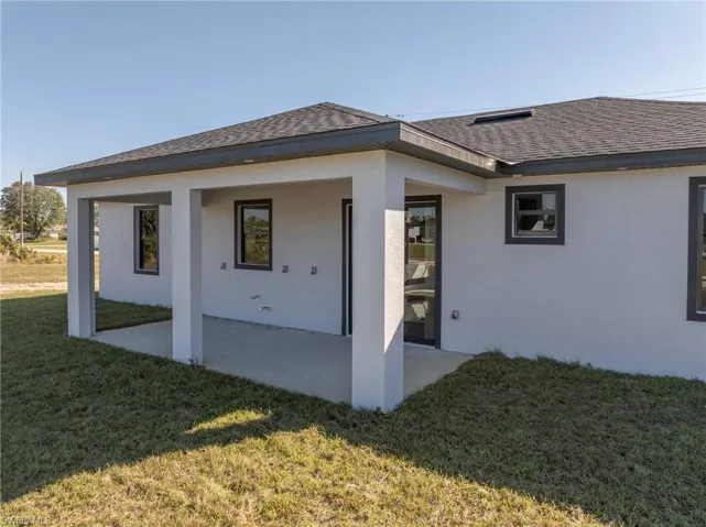 Rear view of house featuring a lawn and a patio area