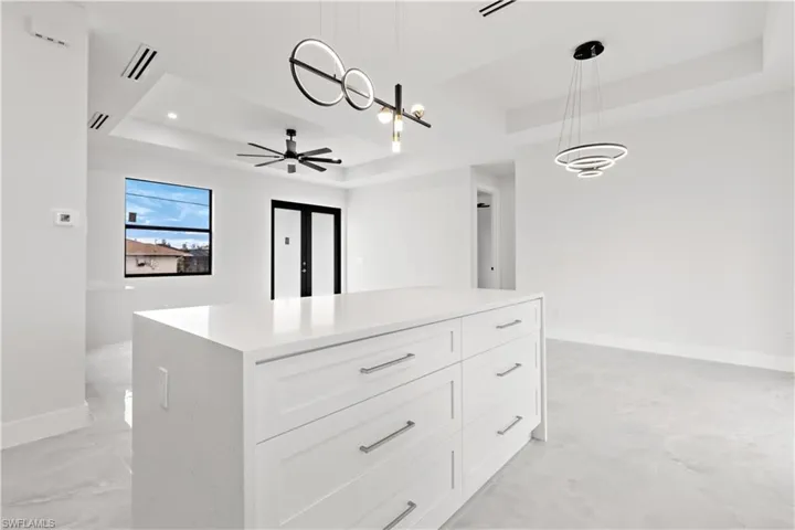 Spacious closet featuring a raised ceiling and ceiling fan
