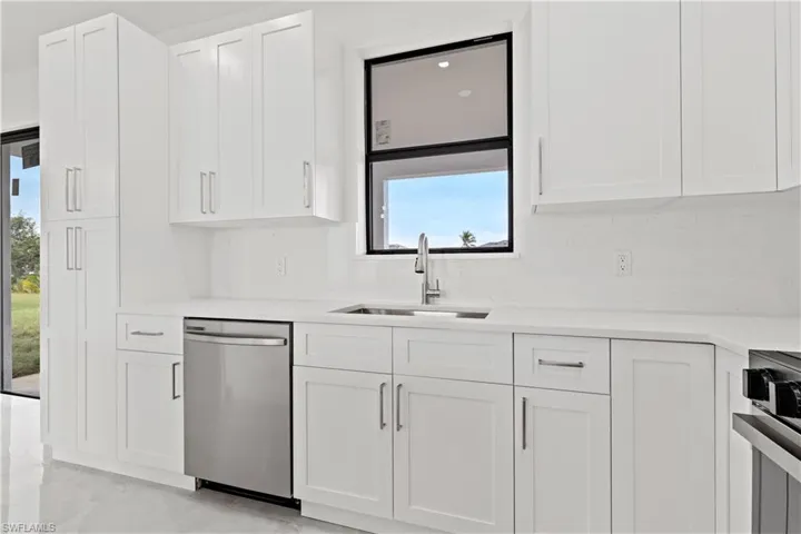 Kitchen featuring white cabinetry, sink, and stainless steel appliances