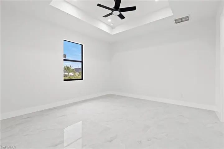 Unfurnished room with a tray ceiling and ceiling fan