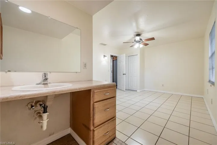 Bathroom with sink, tile patterned floors, and ceiling fan