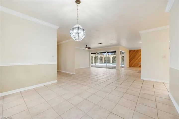Tiled spare room featuring ornamental molding and ceiling fan