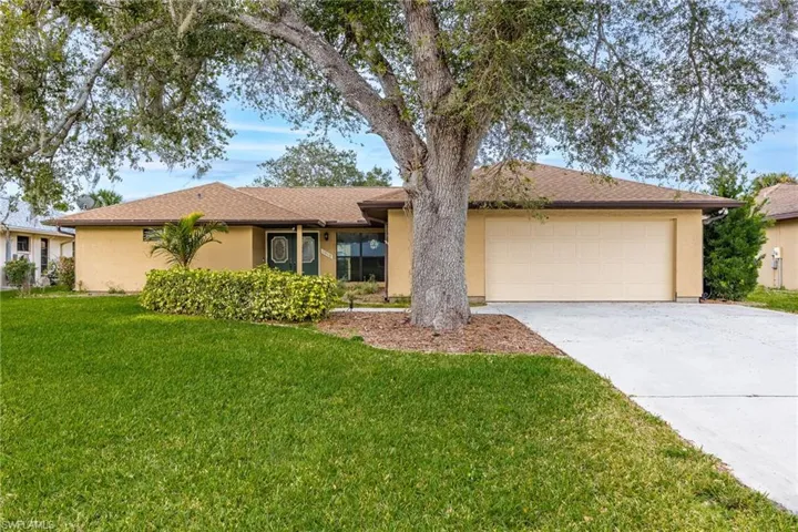 Ranch-style home featuring a garage and a front yard