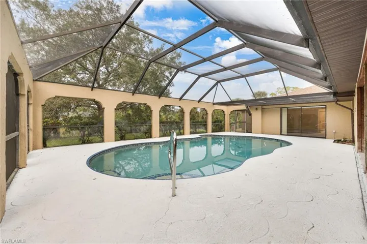View of swimming pool with a lanai and a patio area