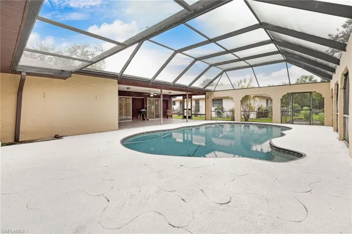 View of swimming pool featuring a patio and glass enclosure