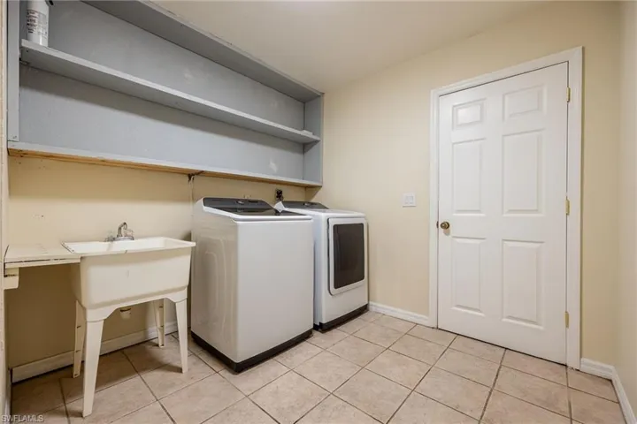Laundry room with light tile patterned flooring and washer and dryer