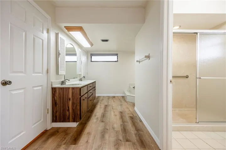 Bathroom featuring vanity, an enclosed shower, and hardwood / wood-style floors